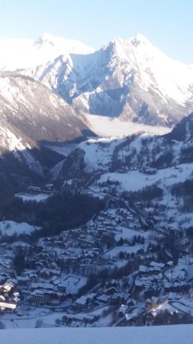 an aerial view of a town with snow covered mountains at Aiguille Noire in Valloire