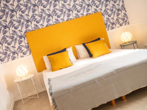 a bedroom with a large bed with a yellow headboard at Casa Blu Guesthouse - Casa de Hospedes in Santa Maria
