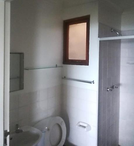baño con aseo y lavabo y ventana en Bona Manzi 7, en Hibberdene