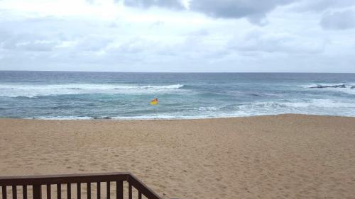 a yellow flag on a beach with the ocean at Bona Manzi 7 in Hibberdene