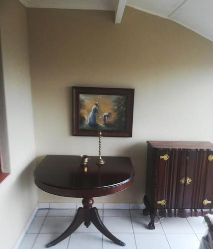 una mesa en una habitación con un cuadro en la pared en Bona Manzi 7, en Hibberdene