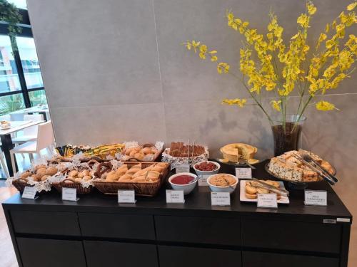 a buffet of pastries and other foods on a table at Astron Suítes Mondial Salvador by Nobile in Salvador