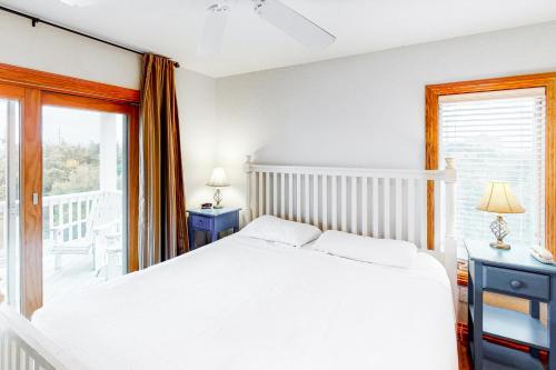 a bedroom with a white bed and a balcony at 7 Day Weekend #33-S in Salvo
