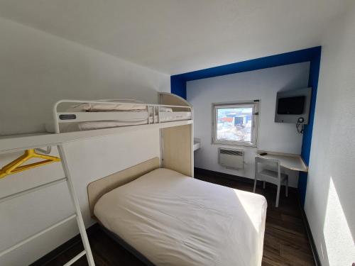 Cette petite chambre comprend des lits superposés et un bureau. dans l'établissement hotelF1 Pontarlier, à Pontarlier