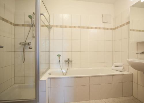 a white bathroom with a tub and a sink at Im Hohlen Seifen 10-H in Winterberg
