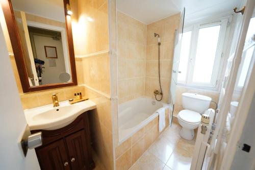 a bathroom with a sink and a toilet and a shower at Hôtel du Château in Vincennes