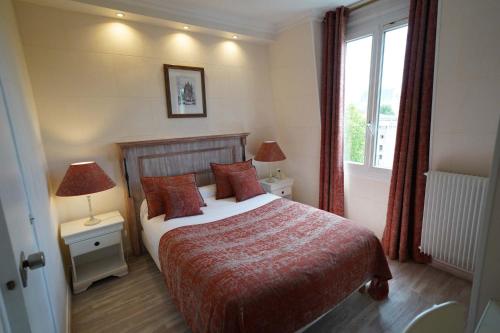 a bedroom with a bed and two lamps and a window at Hôtel du Château in Vincennes