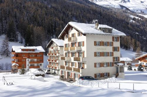a building with snow on top of it in the mountains at Apartment Alpenblick in Saas-Grund