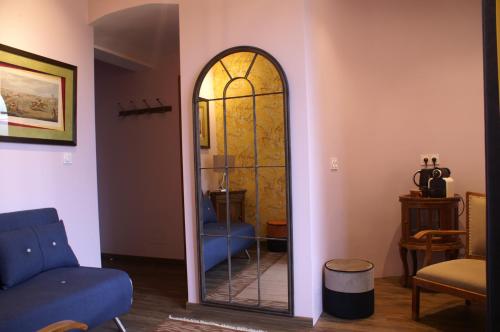 a mirror in a living room with a blue chair at B&B Vassy Etaule in Avallon