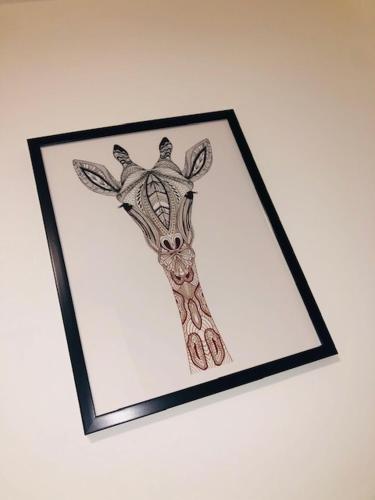 a picture of a giraffe in a frame on a wall at Townhouse @ Corporation Street Stoke in Stoke on Trent