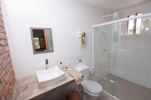a bathroom with a toilet and a sink and a shower at Recanto dos Dendês Chalés in Serra Grande