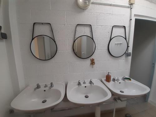 Gîte la Taniere Le jersey في Moidrey: حمام فيه مغسلتين ومرايا على الحائط