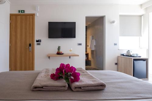 a bedroom with a bed with towels and a flower on it at 180 South Seaside Hotel in Thermisia