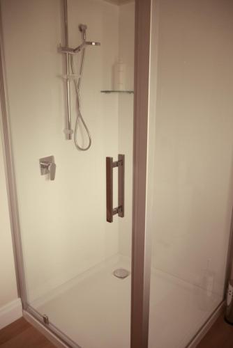 a shower stall in a bathroom with a sink at Apartment on St Georges in Havelock North