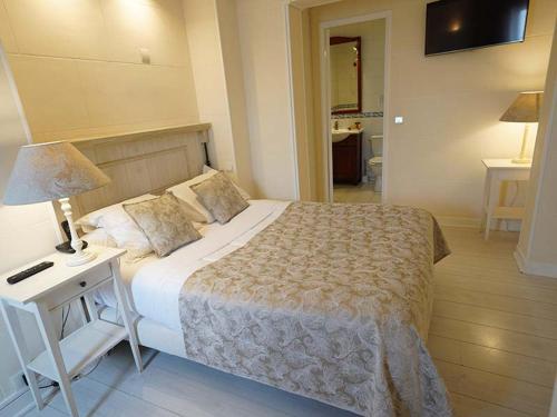 a bedroom with a large bed and a table with a lamp at Hôtel du Château in Vincennes