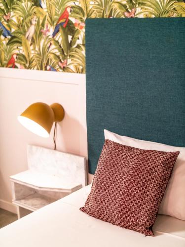 a bed with a pillow and a green wall at Casa Blu Guesthouse - Casa de Hospedes in Santa Maria