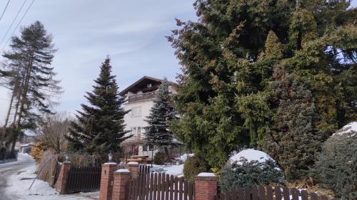 a fence in front of a house in the snow at Alfa 2 apartament 3 in Bystra
