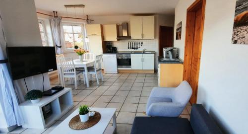 een woonkamer met een bank en een keuken bij Seestern in Werdum