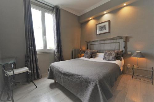 a bedroom with a large bed and a window at Hôtel du Château in Vincennes