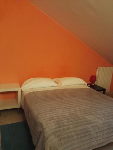a bedroom with a bed and an orange wall at Colle dell'Ara in Chieti