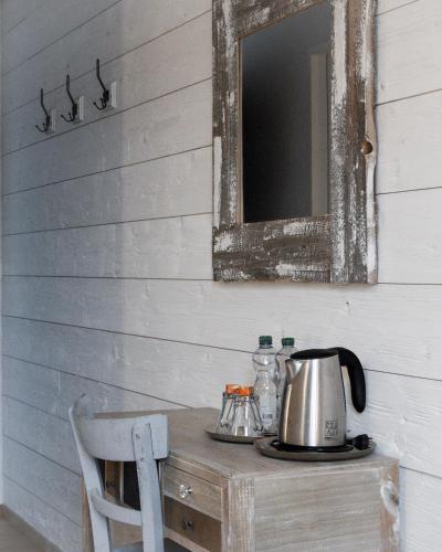 a mirror and a tea kettle on a wooden table at Vent_du_Nord in Tramelan