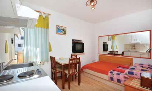 ein Schlafzimmer mit einem Bett und einem Tisch sowie eine Küche in der Unterkunft Sofia studio apartment Sucuraj in Sućuraj