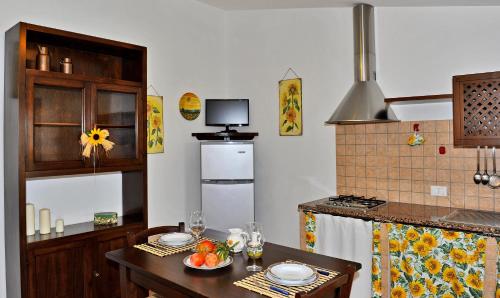 a kitchen with a table and a refrigerator at Agriturismo Bocci in Castiglione della Pescaia