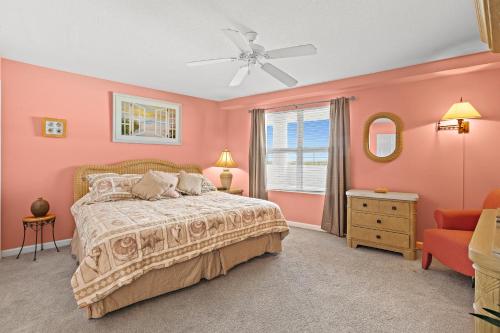 Schlafzimmer mit rosa Wänden, einem Bett und einem Fenster in der Unterkunft Amalfi Coast B420 in Destin