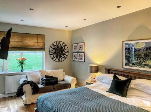 um quarto com uma cama, um sofá e uma janela em The Swan Inn Letton em Letton