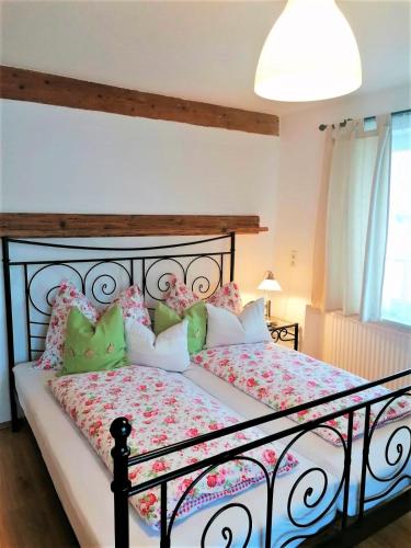 - une chambre dotée d'un grand lit avec des oreillers roses et verts dans l'établissement Come In, à Buch bei Jenbach