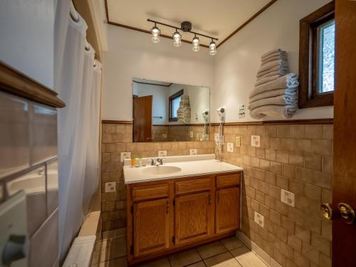 a bathroom with a sink and a mirror at Lake 'N Pines Motel in Cooperstown