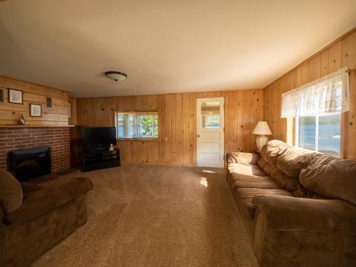 a living room with a couch and a television at Lake 'N Pines Motel in Cooperstown