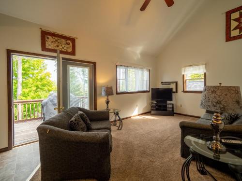 a living room with two couches and a tv at Lake 'N Pines Motel in Cooperstown