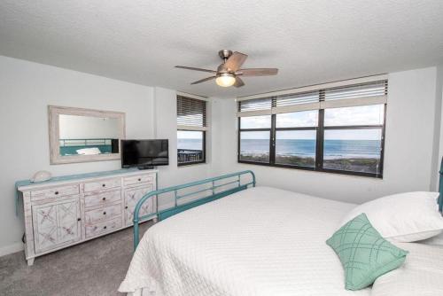 1 dormitorio con 1 cama y TV de pantalla plana en Barefoot Trace 303, en Crescent Beach
