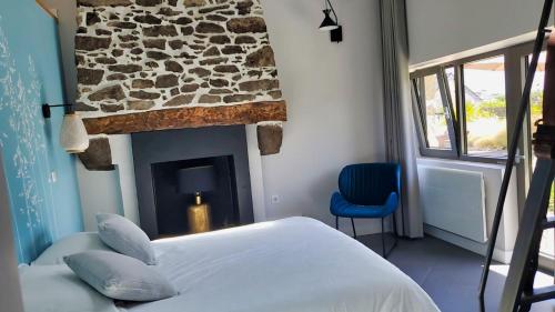 Schlafzimmer mit einem Bett und einem Steinkamin in der Unterkunft Le Temps de Vivre in Plouescat