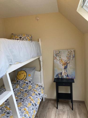a bedroom with two bunk beds and a painting of a deer at Au Bois de Rosée in Florennes