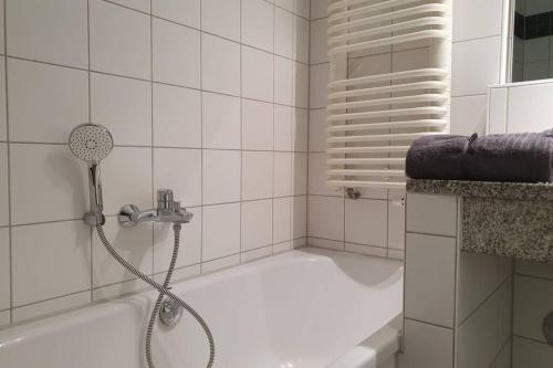 a bathroom with a bath tub with a shower at Shopping street Gewandhaus Netflx Badew. 58zolltv in Leipzig