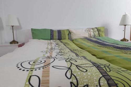 a bedroom with two beds with green and white sheets at Shopping street Gewandhaus Netflx Badew. 58zolltv in Leipzig