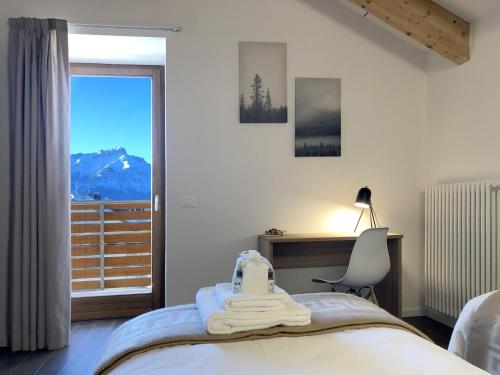 a bedroom with a bed and a desk and a window at Residence Aurora in Lavarone