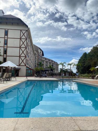 a large swimming pool in front of a building at Apart Pedra Azul in Pedra Azul
