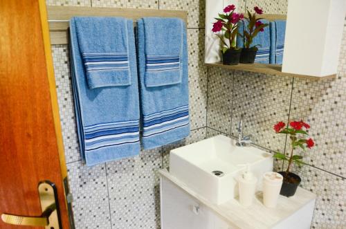 a bathroom with blue towels and a sink at Chalé vista da mata in Visconde De Maua