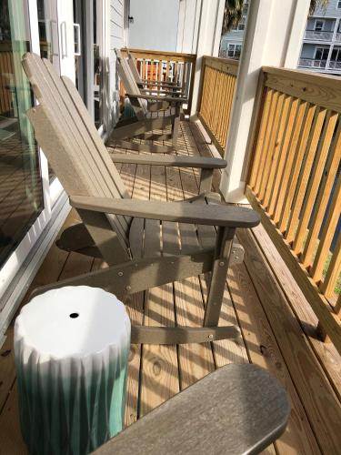 a row of chairs on a porch with a candle at New! HEATED POOL, BEACH HOUSE, Elevator, Walk to the Beach! in Hilton Head Island