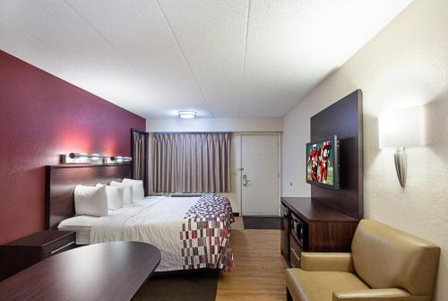 Habitación de hotel con cama y escritorio en Red Roof Inn Dayton - Fairborn/Nutter Center, en Fairborn