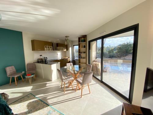 Il dispose d'une cuisine et d'un salon avec une table et des chaises en verre. dans l'établissement Porto-Vecchio, Luxe et lumière, Stanatura, à Porto-Vecchio