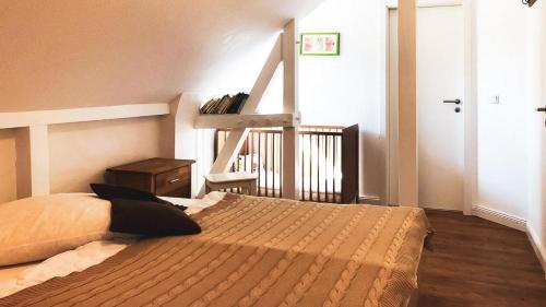 ein Schlafzimmer mit einem Bett und einem Treppenaufgang in der Unterkunft Haus Alte Bäckerei Deichgraf in Born