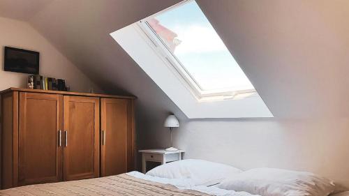 ein Schlafzimmer mit einem Bett und einem Dachfenster in der Unterkunft Haus Alte Bäckerei Deichgraf in Born