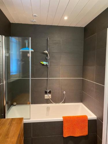 a bathroom with a bath tub with a shower at L'Esprit d'O in Lacanau