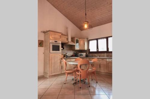 - une cuisine avec une table et des chaises dans l'établissement Maison entière au pied du plateau du retord 2 chambres SDB - Vouvray, à Ochiaz