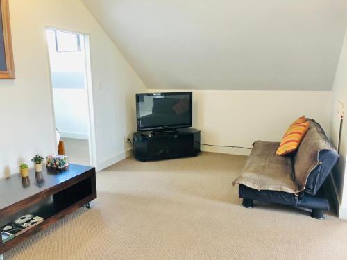 a living room with a couch and a tv at Spacious, Peaceful, Fully Equipped 1BR Apartment in Upper Hutt