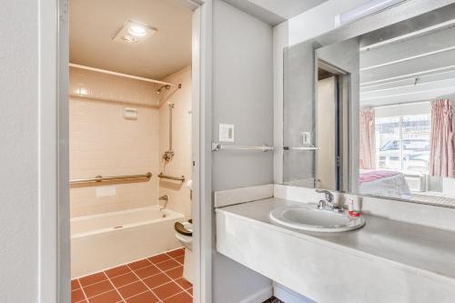 a bathroom with a sink and a mirror at OXFORD INN, Lincoln Blvd in Oklahoma City